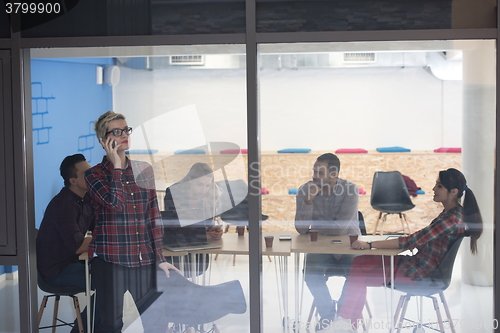 Image of business woman in meeting room  speaking by cell phone