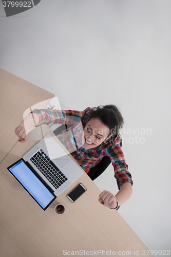 Image of top view of young business woman working on laptop