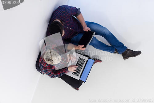 Image of top view of  couple working on laptop computer at startup office