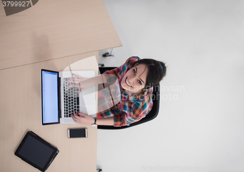 Image of top view of young business woman working on laptop