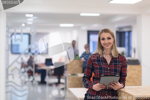 Image of portrait of young business woman at office with team in backgrou