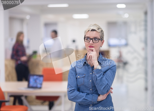 Image of portrait of young business woman at office with team in backgrou