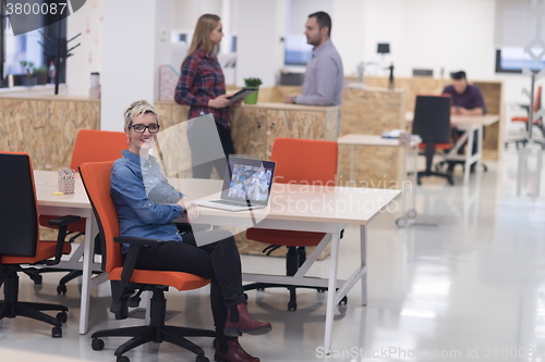 Image of portrait of young business woman at office with team in backgrou