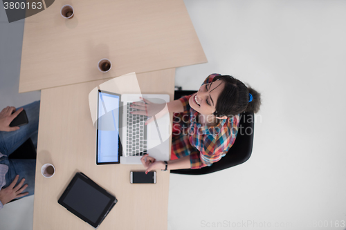 Image of top view of young business woman working on laptop