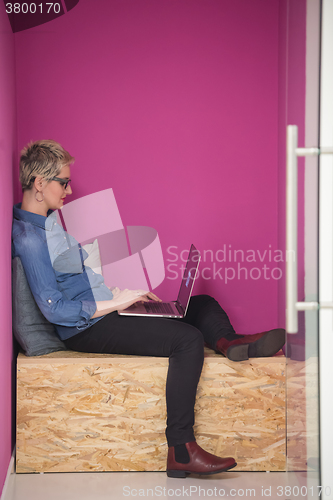 Image of woman in crative box working on laptop