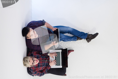 Image of top view of  couple working on laptop computer at startup office