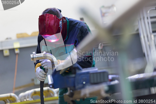 Image of Industrial worker welding in metal factory.