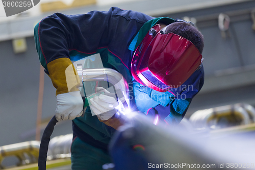 Image of Industrial worker welding in metal factory.