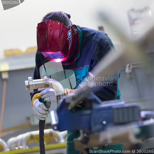 Image of Industrial worker welding in metal factory.