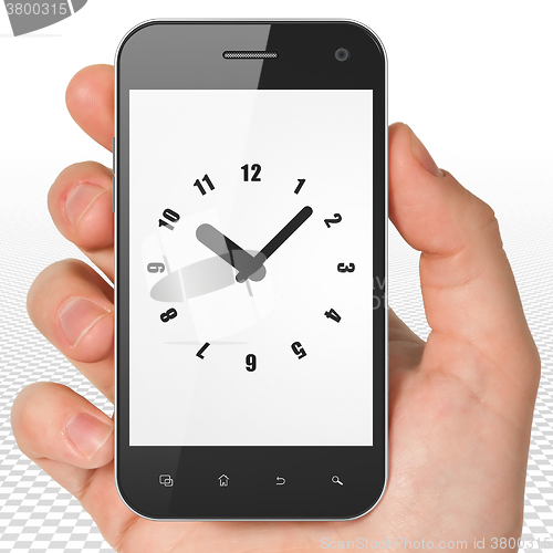 Image of Time concept: Hand Holding Smartphone with Clock on display