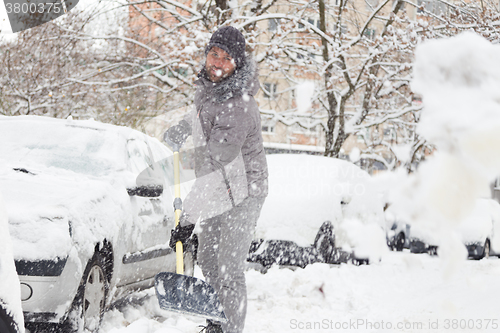 Image of Man shoveling snow in winter.