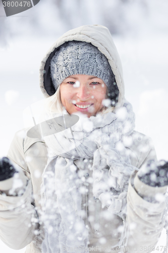 Image of Girl  playing with snow in winter.