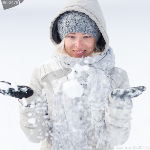 Image of Girl  playing with snow in winter.