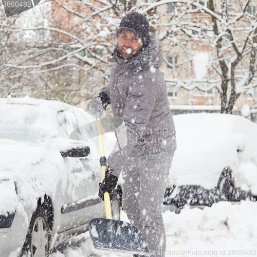 Image of Man shoveling snow in winter.