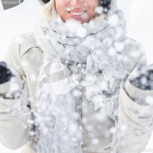 Image of Girl  playing with snow in winter.