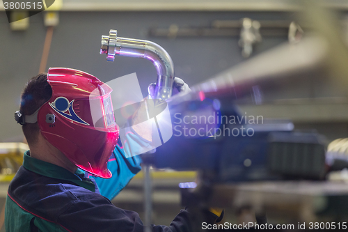 Image of Industrial worker welding in metal factory.