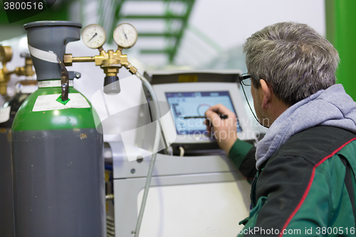 Image of Industrial worker setting orbital welding machine.