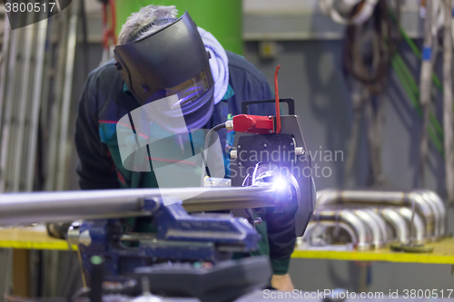 Image of Industrial worker setting orbital welding machine.