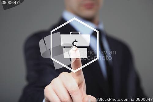 Image of Businessman presses digital interface dollar sign 