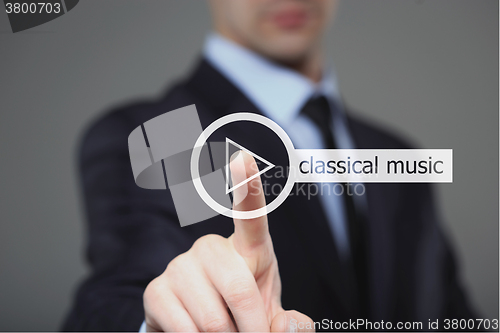 Image of Businessman pressing play classical music button 