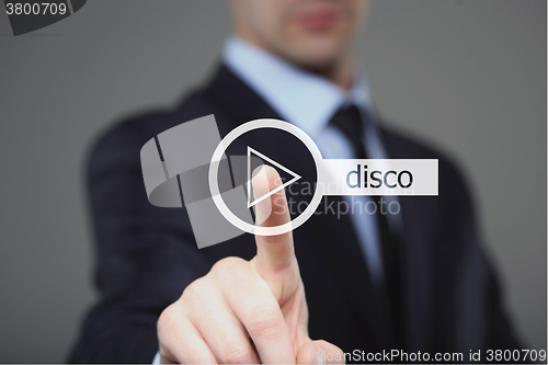 Image of Businessman pressing play disco music button 