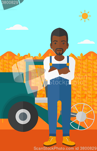 Image of Man standing with combine on background.