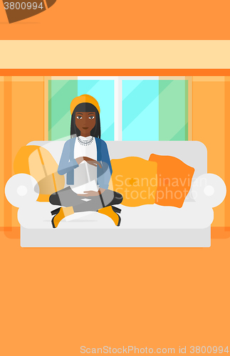 Image of Pregnant woman sitting on sofa.