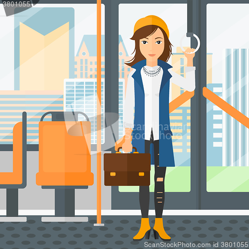 Image of Woman standing inside public transport.