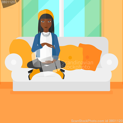 Image of Pregnant woman sitting on sofa.