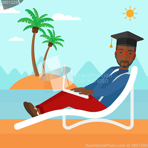 Image of Graduate lying on chaise lounge with laptop.