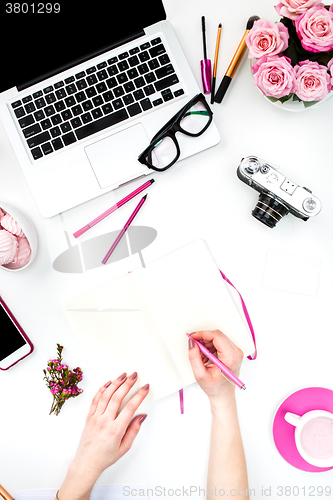 Image of The female hands writing against fashion woman objects