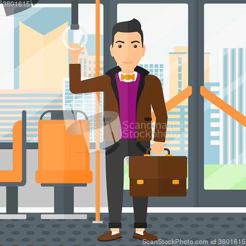 Image of Man standing inside public transport.