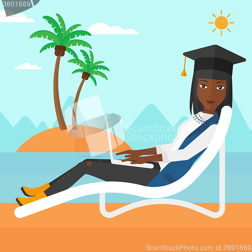 Image of Graduate lying on chaise lounge with laptop.