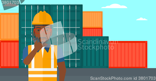 Image of Stevedore standing on cargo containers background.