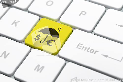 Image of Security concept: Money And Umbrella on computer keyboard background