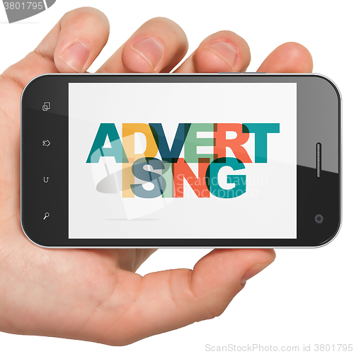 Image of Marketing concept: Hand Holding Smartphone with Advertising on  display