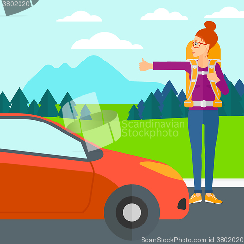 Image of Young woman hitchhiking.