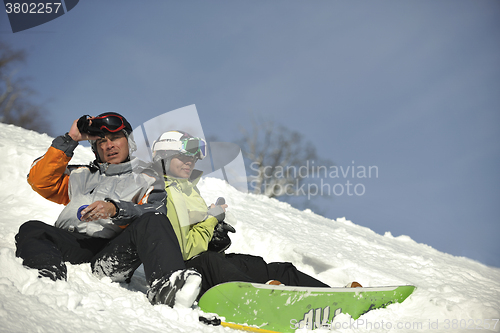 Image of snowboarders couple relaxing