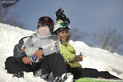 Image of snowboarders couple relaxing