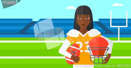 Image of Rugby player with ball and helmet in hands.