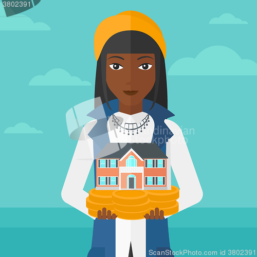 Image of Woman holding house model.