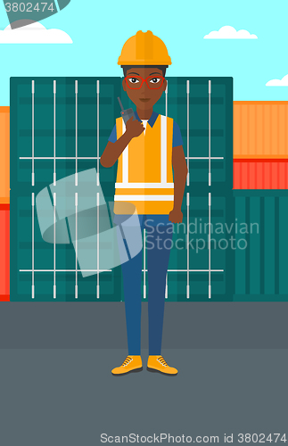 Image of Stevedore standing on cargo containers background.