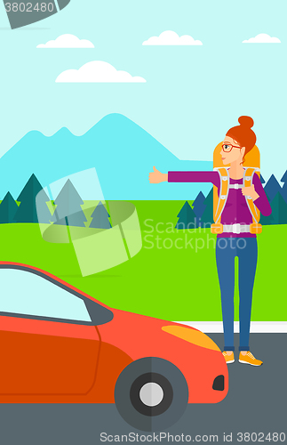 Image of Young woman hitchhiking.