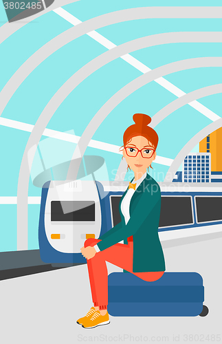 Image of Woman sitting on railway platform.