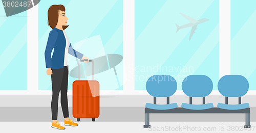 Image of Woman at airport with suitcase.