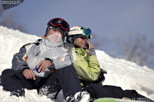 Image of snowboarders couple relaxing