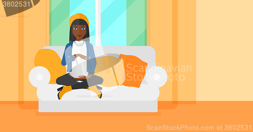 Image of Pregnant woman sitting on sofa.