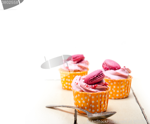 Image of pink berry cream cupcake with macaroon on top