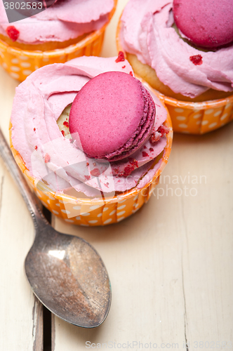 Image of pink berry cream cupcake with macaroon on top