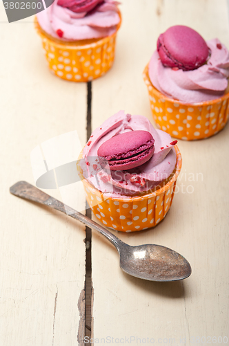 Image of pink berry cream cupcake with macaroon on top